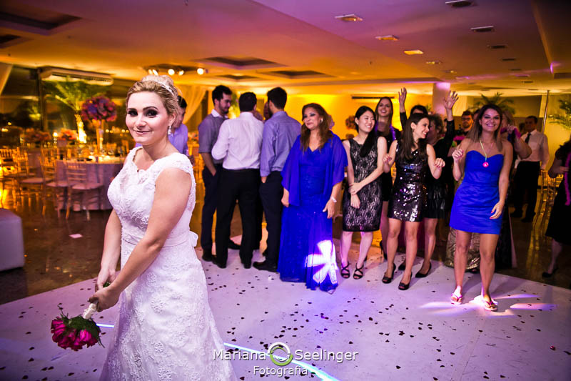 Noiva jogando o bouquet em casa de festa em niterói em casamento registrado por Mariana Seelinger Fotografia de Casamentos e Familias em Niterói RJ
