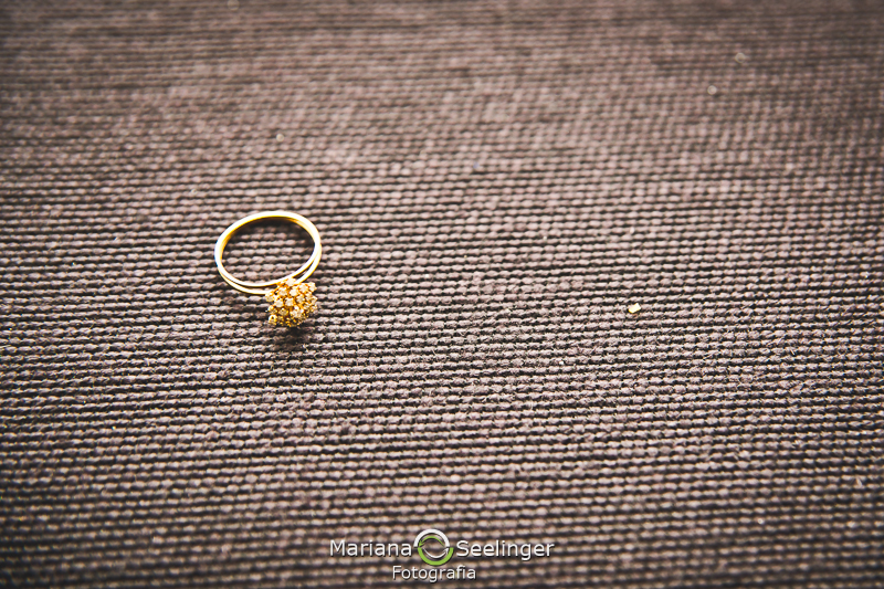 Foto do aparador de aliança de ouro com funfo cinza em casamento registrado por Mariana Seelinger Fotografia de Casamentos e Familias em Niterói RJ