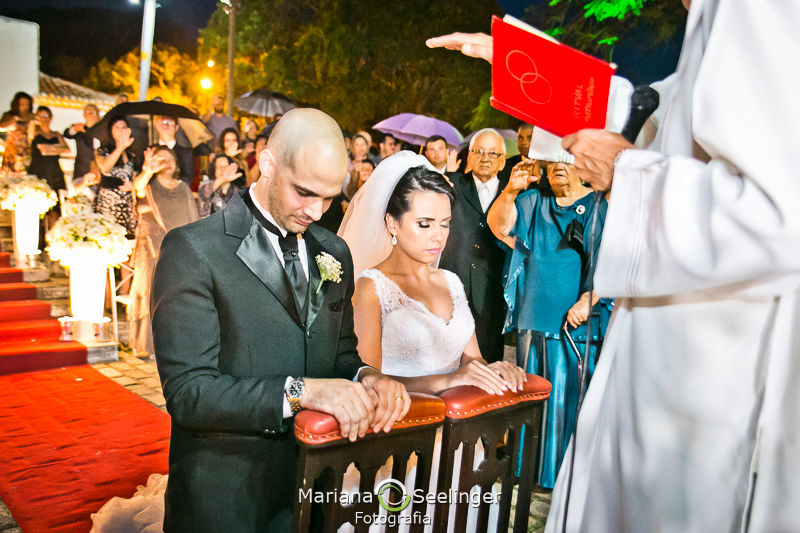 Casal recebendo a benção ajoelhados em casamento registrado por Mariana Seelinger Fotografia de Casamentos e Familias em Niterói RJ