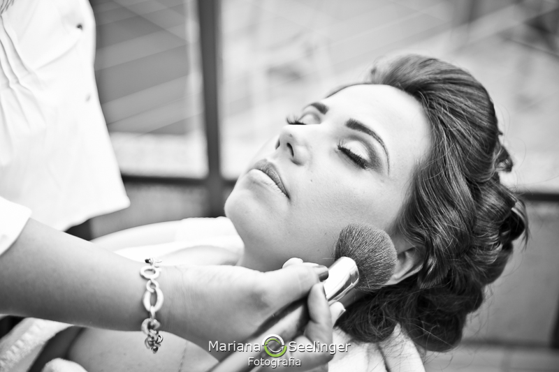 Noiva se maquiando com blush em making of em casamento registrado por Mariana Seelinger Fotografia de Casamentos e Familias em Niterói RJ