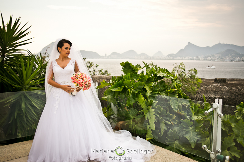 Noiva com bouquet de flores coloridas em sacada da varanda de hotel em niterói em casamento registrado por Mariana Seelinger Fotografia de Casamentos e Familias em Niterói RJ