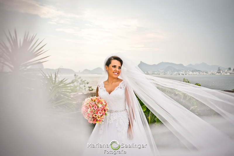 Noiva posando com bouquet em foto de making of na sacada do hotel mercure em casamento registrado por Mariana Seelinger Fotografia de Casamentos e Familias em Niterói RJ