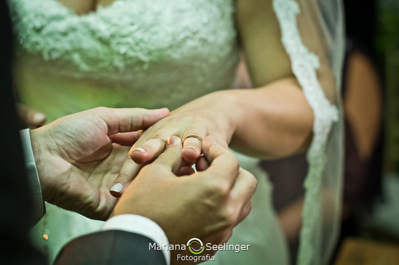 Noivo colocando aliança no dedo da noiva em casamento registrado por Mariana Seelinger Fotografia de Casamentos e Familias em Niterói RJ