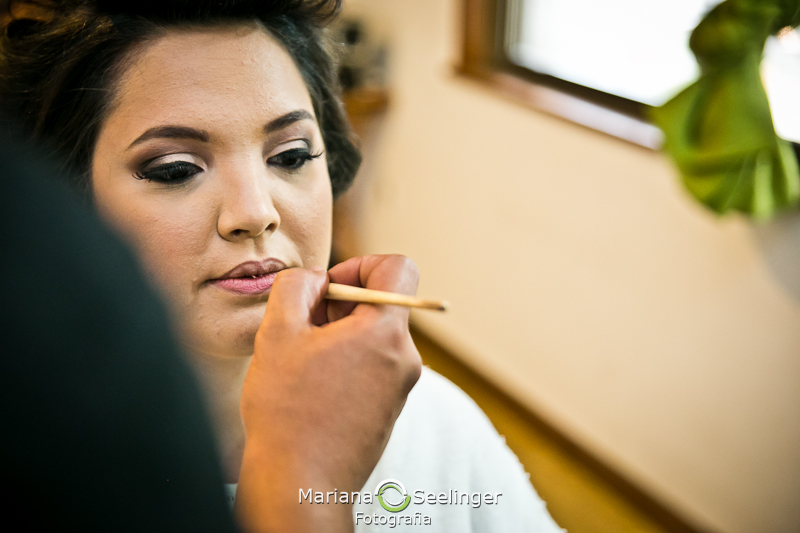 Noiva se maquiando em making of em casamento registrado por Mariana Seelinger Fotografia de Casamentos e Familias em Niterói RJ