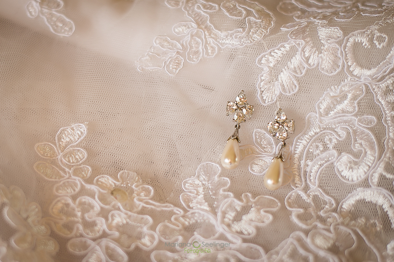 foto do brinco da noiva no dia do casamento durante o making of sobre a renda do vestido em fotografia de mariana seelinger