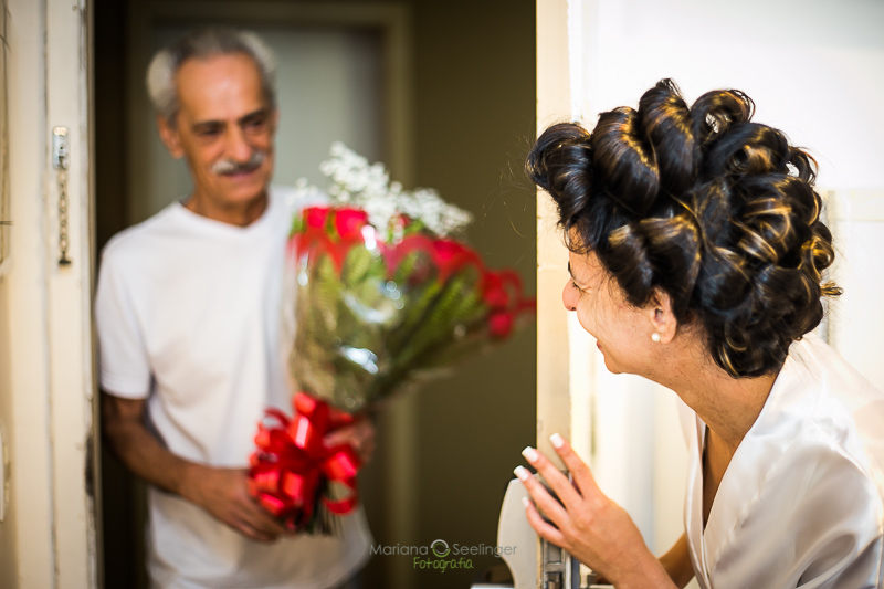 Noiva recebendo flores do pai em making of em casamento registrado por Mariana Seelinger Fotografia de Casamentos e Familias em Niterói RJ