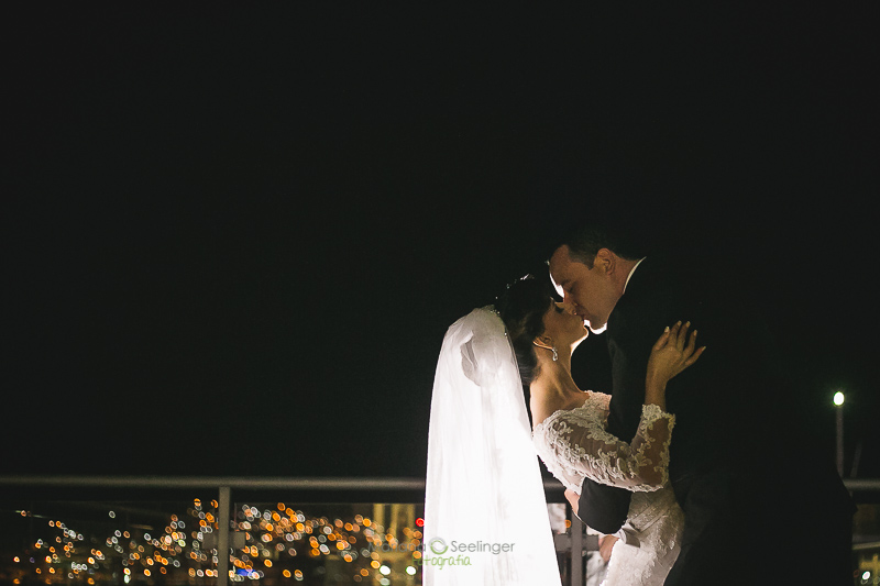 Foto do casal de noivos se beijando na sacada da casa de festa em casamento registrado por Mariana Seelinger Fotografia de Casamentos e Familias em Niterói RJ