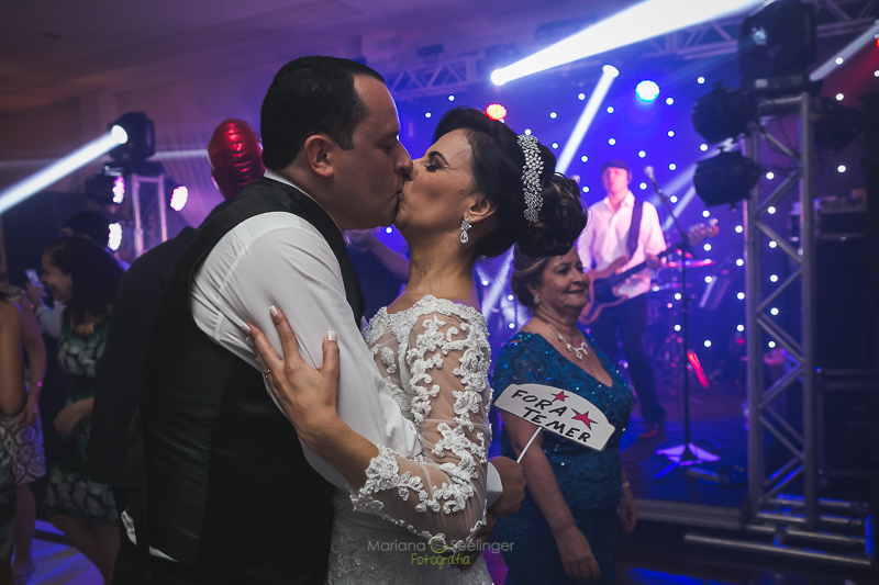 Noivo e noiva se beijando em pista de dança em casamento registrado por Mariana Seelinger Fotografia de Casamentos e Familias em Niterói RJ