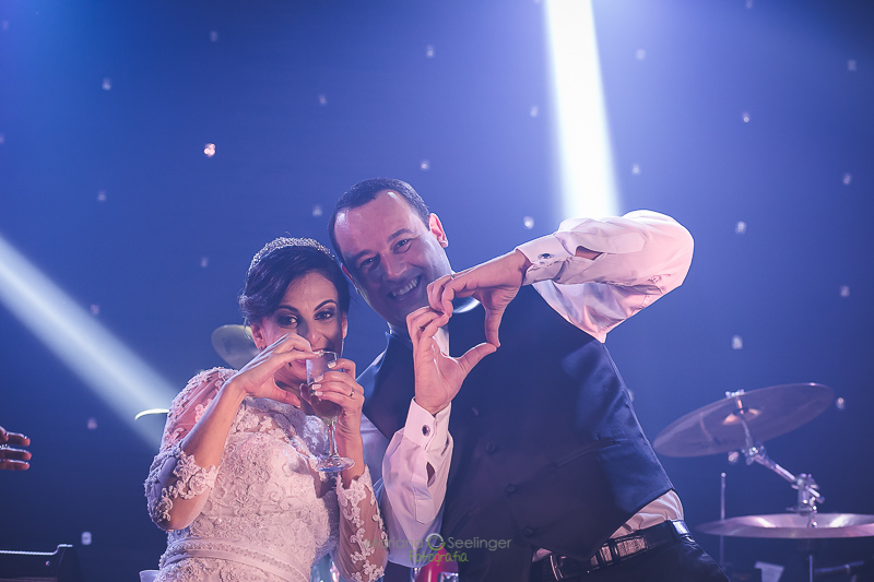 Casal de noivos fazendo coração com a mão para foto em casamento registrado por Mariana Seelinger Fotografia de Casamentos e Familias em Niterói RJ