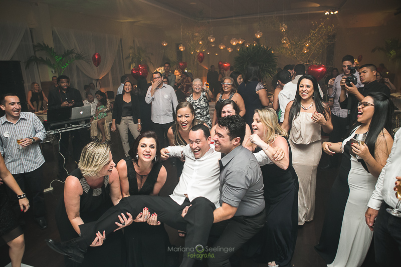 Convidados do casamento com noivo no colo em casamento registrado por Mariana Seelinger Fotografia de Casamentos e Familias em Niterói RJ