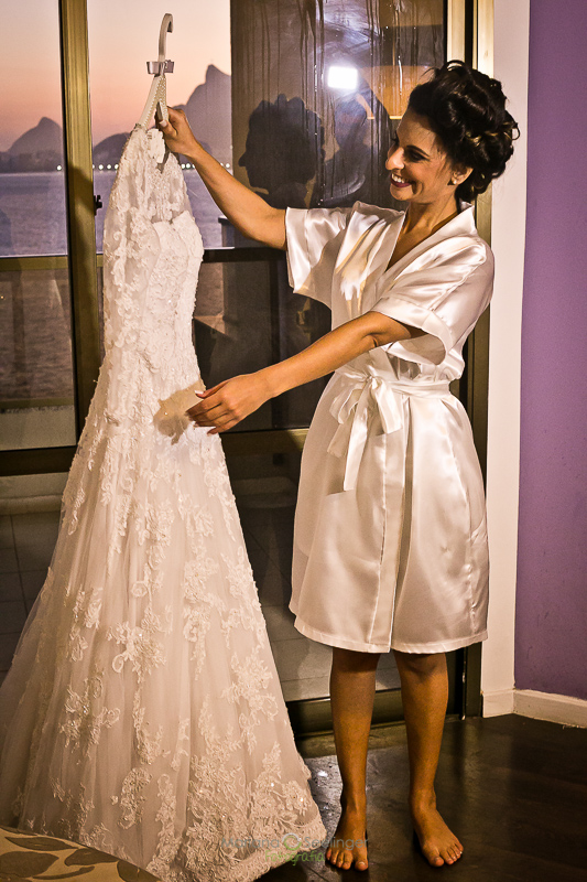 Noiva vendo vestido bordado em making of em hotel mercure em casamento registrado por Mariana Seelinger Fotografia de Casamentos e Familias em Niterói RJ