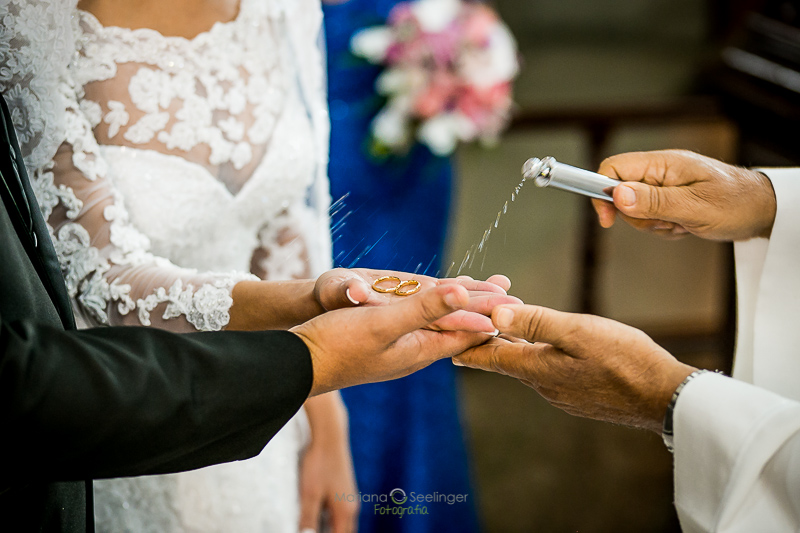 Celebrante do casamento abençoando as alianças em casamento registrado por Mariana Seelinger Fotografia de Casamentos e Familias em Niterói RJ