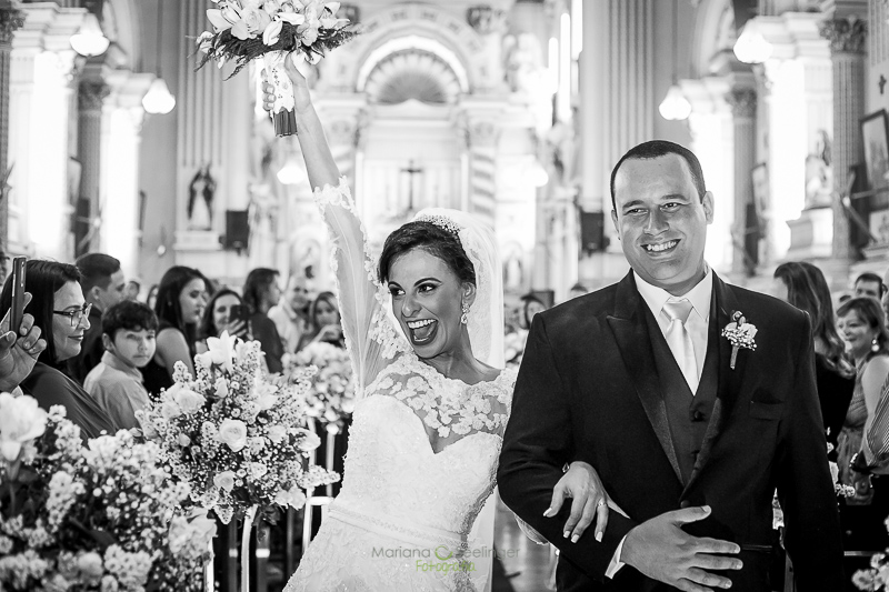 Noiva comemorando ao sair da igreja em casamento registrado por Mariana Seelinger Fotografia de Casamentos e Familias em Niterói RJ