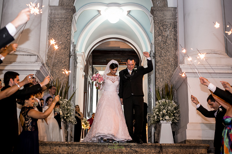 Casal de noivos saindo da igreja em casamento registrado por Mariana Seelinger Fotografia de Casamentos e Familias em Niterói RJ