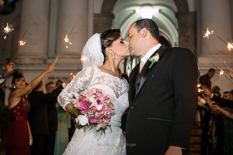 Noivos se beijando na saida da igreja em casamento registrado por Mariana Seelinger Fotografia de Casamentos e Familias em Niterói RJ