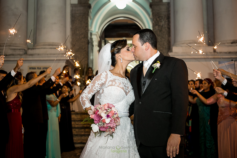 Noiva e noivo se beijando a saida da igreja em casamento registrado por Mariana Seelinger Fotografia de Casamentos e Familias em Niterói RJ