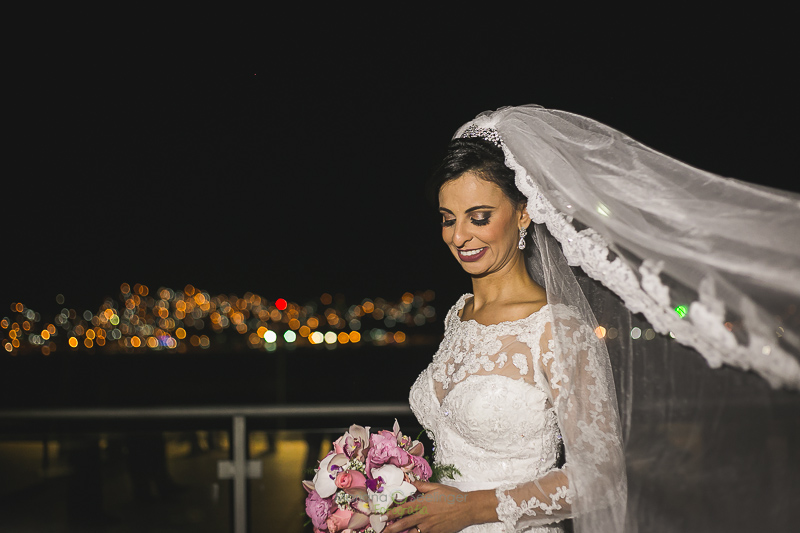 Foto da noiva na sacada da casa de festa com bouquet de flores rosas e brancas em casamento registrado por Mariana Seelinger Fotografia de Casamentos e Familias em Niterói RJ