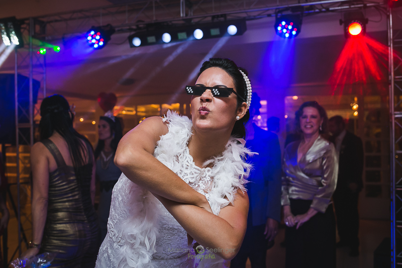 Noiva com óculos escuro na pista de dança em casamento registrado por Mariana Seelinger Fotografia de Casamentos e Familias em Niterói RJ