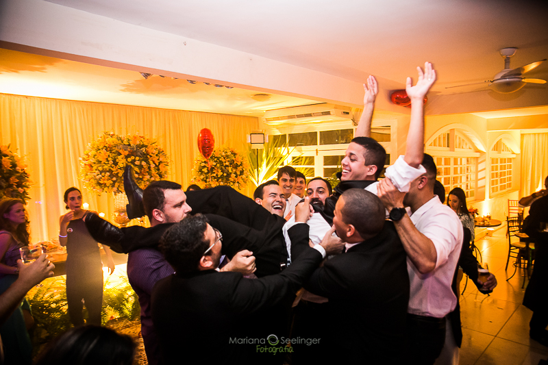 Noivo sendo jogado pro alto pelos seus convidados em casamento registrado por Mariana Seelinger Fotografia de Casamentos e Familias em Niterói RJ