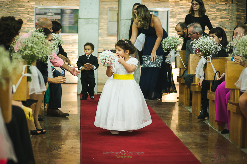 Daminha de casamento a caminho do altar em casamento registrado por Mariana Seelinger Fotografia de Casamentos e Familias em Niterói RJ