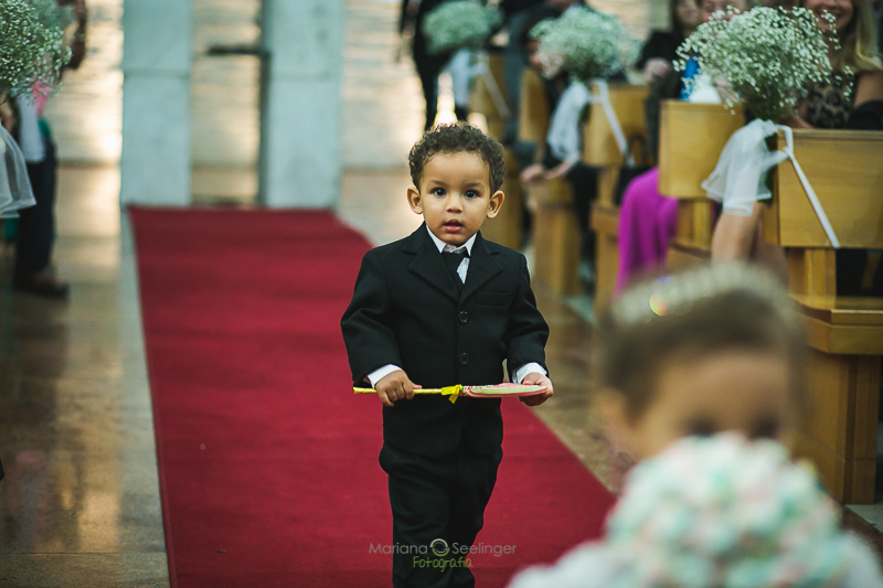 Pajem do casamento a caminho do altar em casamento registrado por Mariana Seelinger Fotografia de Casamentos e Familias em Niterói RJ