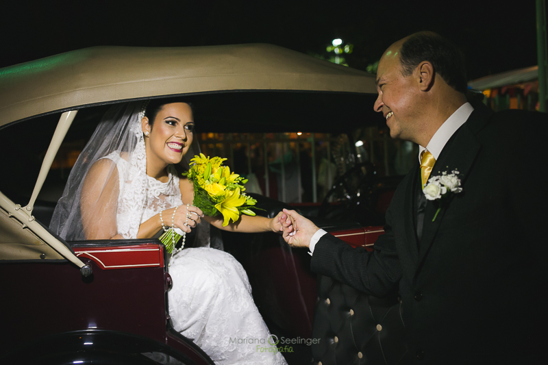 Noiva saindo do carro em casamento registrado por Mariana Seelinger Fotografia de Casamentos e Familias em Niterói RJPai dando