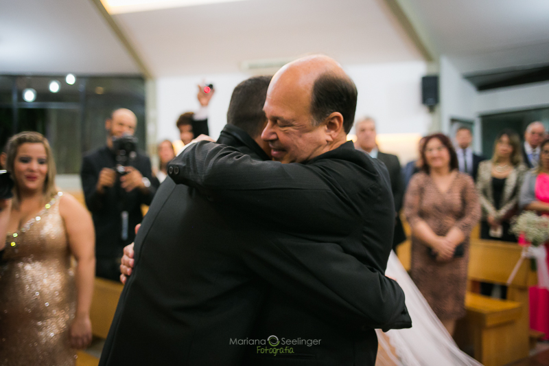 Pai da noiva abraçando noivo em casamento registrado por Mariana Seelinger Fotografia de Casamentos e Familias em Niterói RJ