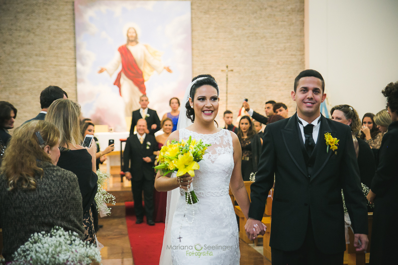Noivo e noiva saindo do altar em casamento registrado por Mariana Seelinger Fotografia de Casamentos e Familias em Niterói RJ