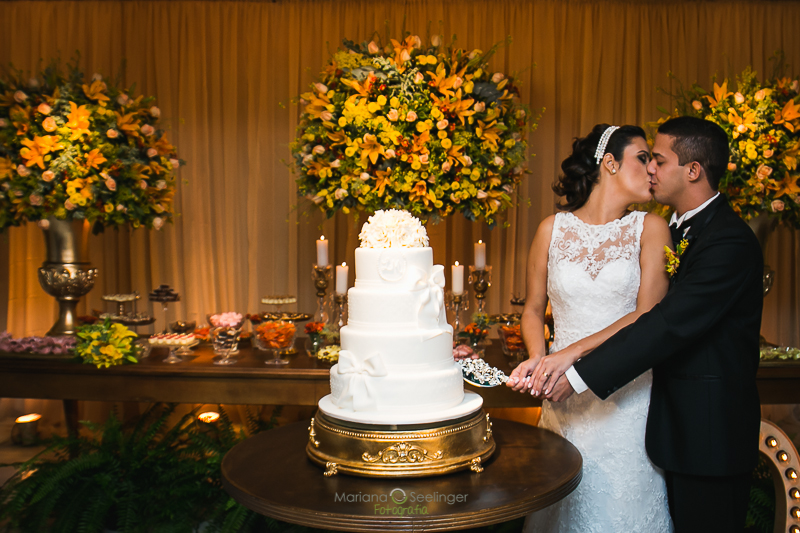 casal de noivos cortando bolo brande de 3 andares em casamento registrado por Mariana Seelinger Fotografia de Casamentos e Familias em Niterói RJ