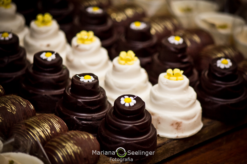 Doces finos de casamento brancos e pretos apoiados em caixa de madeira rústica em fotografia de Mariana Seelinger Fotógrafa de Casamentos em Niterói e RJ