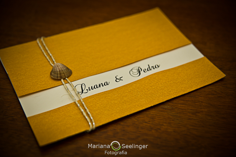 Convite de casamento em cima de mesa rústica de madeira em fotografia de Mariana Seelinger Fotógrafa de Casamentos em Niterói e RJ
