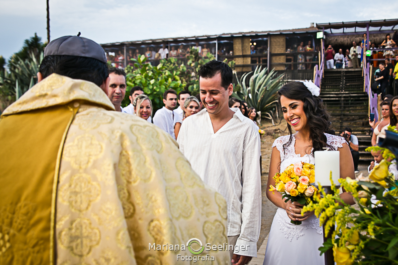 Noivos escutando o celebrante de casamentosem fotografia de Mariana Seelinger Fotógrafa de Casamentos em Niterói e RJ