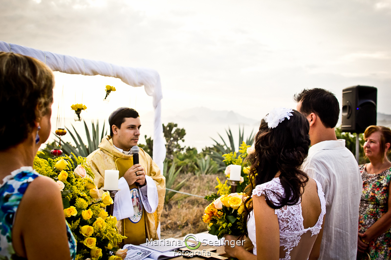 Celebrante conversando com noivos na praia de camboinhas em fotografia de Mariana Seelinger Fotógrafa de Casamentos em Niterói e RJ