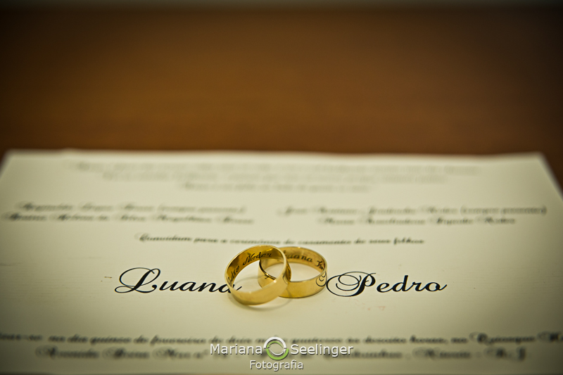 Aliança e convite do casal em cima da mesa de madeira rustica em fotografia de Mariana Seelinger Fotógrafa de Casamentos em Niterói e RJ