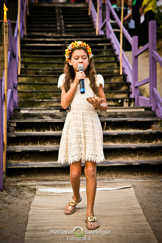 Daminha cantando para os noivos em casamento na praia de camboinhas em fotografia de Mariana Seelinger Fotógrafa de Casamentos em Niterói e RJ