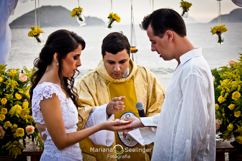 Casal de noivos sendo abençoados pelo celebrante de casamentos em fotografia de Mariana Seelinger Fotógrafa de Casamentos em Niterói e RJ