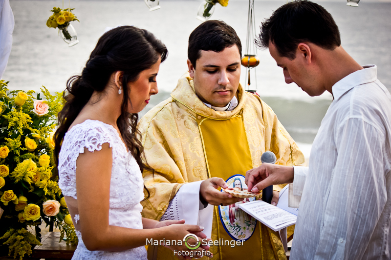 Foto do noivo pegando a aliança na bandeja com o celabrante em fotografia de Mariana Seelinger Fotógrafa de Casamentos em Niterói e RJ