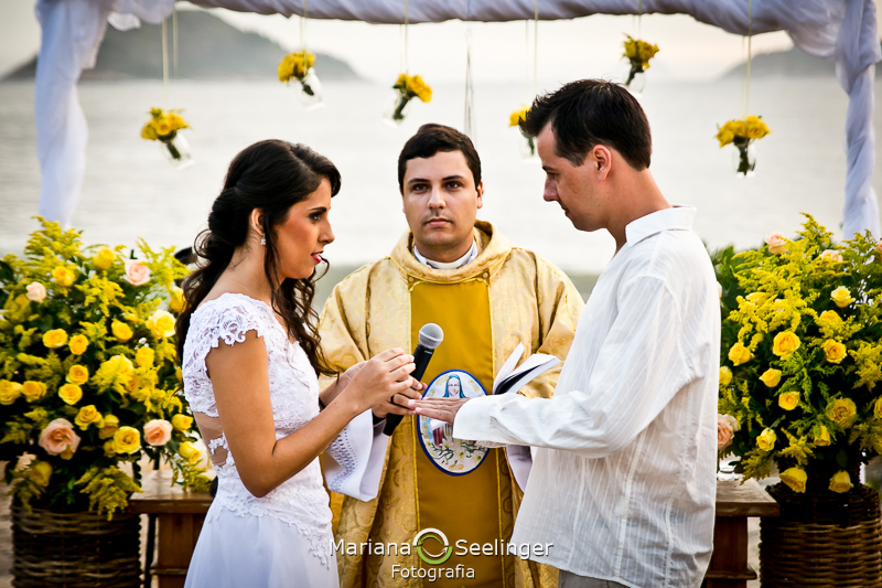 Noiva trocando aliança no altar na praia de camboinhas em fotografia de Mariana Seelinger Fotógrafa de Casamentos em Niterói e RJ