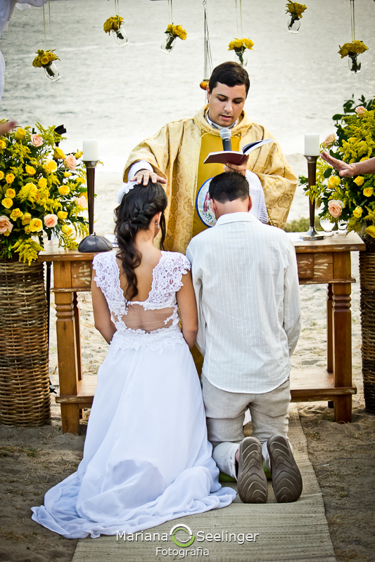 Noivos ajoelhados no altar em fotografia de Mariana Seelinger Fotógrafa de Casamentos em Niterói e RJ