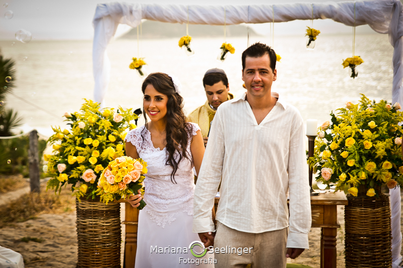 Noivo e noiva saindo do altar de mão dadas em fotografia de Mariana Seelinger Fotógrafa de Casamentos em Niterói e RJ