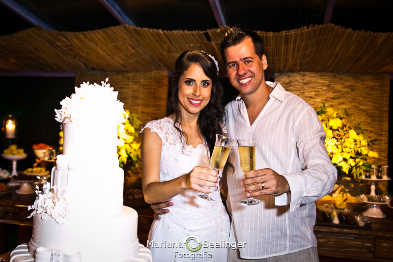 Casal de noivos brindando assim que chegaram na festa em fotografia de Mariana Seelinger Fotógrafa de Casamentos em Niterói e RJ