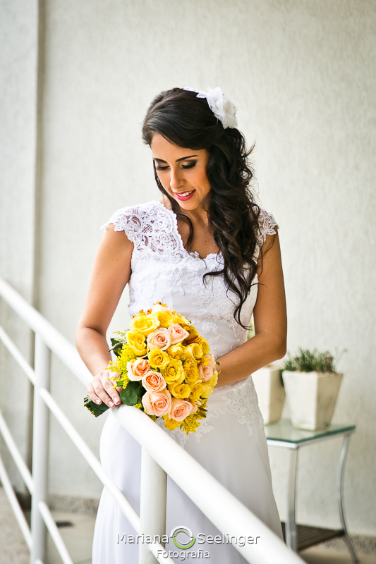 Noiva com vestido boho segurando bouquet amarelo e branco em fotografia de Mariana Seelinger Fotógrafa de Casamentos em Niterói e RJ