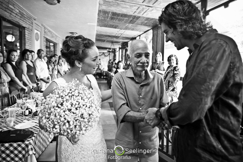 pai da noiva entregando sua filha ao seu futuro marido em fotografia de Mariana Seelinger Fotógrafa de Casamentos em Niterói e RJ