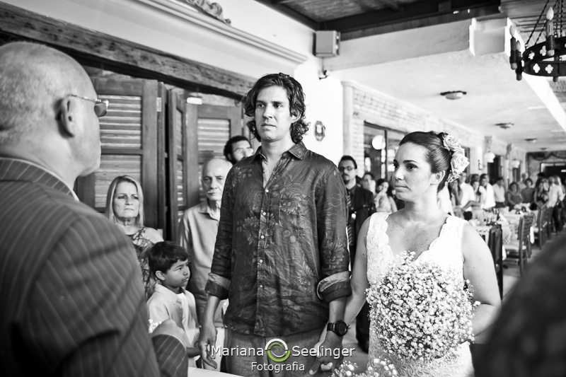 Noivos escutando o celebrante de casamento em fotografia de Mariana Seelinger Fotógrafa de Casamentos em Niterói e RJ