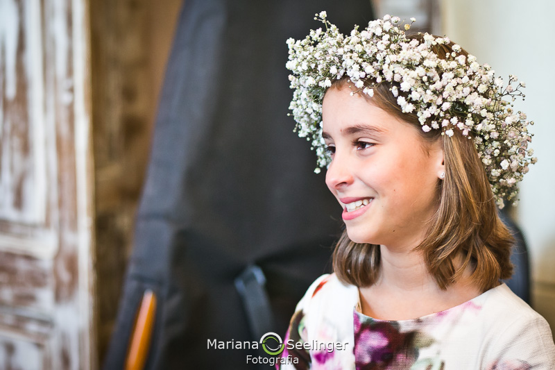 Daminha filha dos noivos emocionada durante o casamento de seus pais em fotografia de Mariana Seelinger Fotógrafa de Casamentos em Niterói e RJ