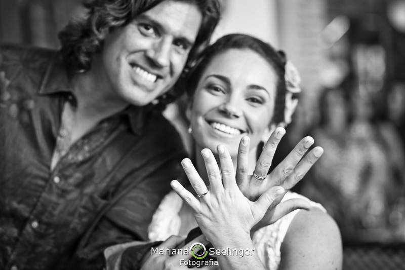 Fotografia bem detalhada das alianças na mão do casal de noivos em fotografia de Mariana Seelinger Fotógrafa de Casamentos em Niterói e RJ