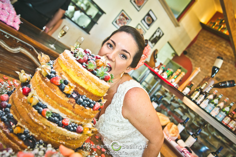Noiva mordendo o bolo em fotografia de Mariana Seelinger Fotógrafa de Casamentos em Niterói e RJ