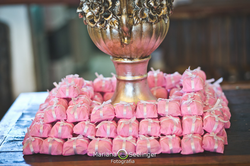 Bem casados em volta de uma taça de ferro em cima de uma mesa de madeira rústica em fotografia de Mariana Seelinger Fotógrafa de Casamentos em Niterói e RJ