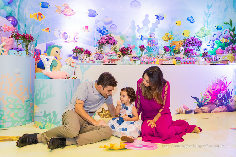 Foto da aniversariante com os pais na sua festa de anviersario com a decoracção fundo do mar no pipas em Maringa.