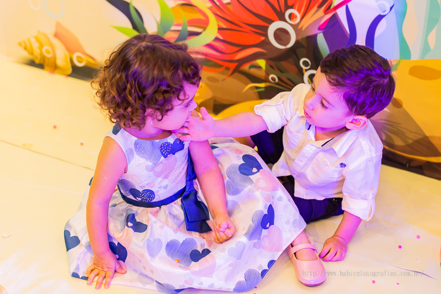 Fofografia da aniversariante com o priminho sentados no chao